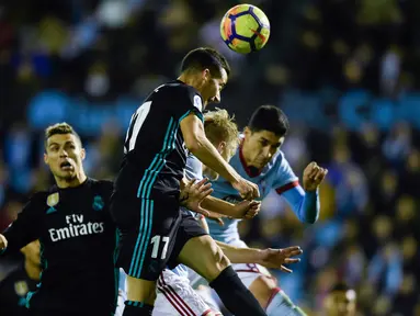 Gelandang Real Madrid Lucas Vazquez menyundul bola pada pertandingan pekan ke-18 La Liga kontra Celta Vigo di Estadio de Balaidos, Minggu (7/1). Sempat unggul berkat dua gol Gareth Bale, Madrid akhirnya harus puas dengan skor akhir 2-2. (MIGUEL RIOPA/AFP)