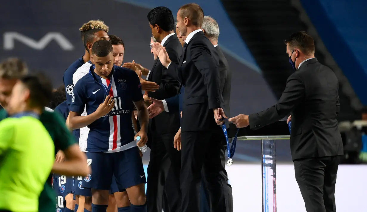 Penyerang PSG, Kylian Mbappe (kiri) menerima medalinya dari Presiden UEFA Aleksander Ceferin (kanan) setelah pertandingan final Liga Champions melawan ayern Munchen di stadion Luz di Lisbon, Portugal, Minggu, (23/8/2020). Bayern Munchen menang tipis atas PSG 1-0. (AFP/Lluis Gene)