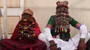 Sepasang pengantin mengenakan baju tradisional saat menjalani prosesi pernikahan massal di Karachi, Pakistan, (19/3). Sebanyak 62 pasangan pengantin mengikuti pernikahan massal yang merupakan bagian dari perayaan Festival Holi.  (AFP Photo /Asif Hassan)