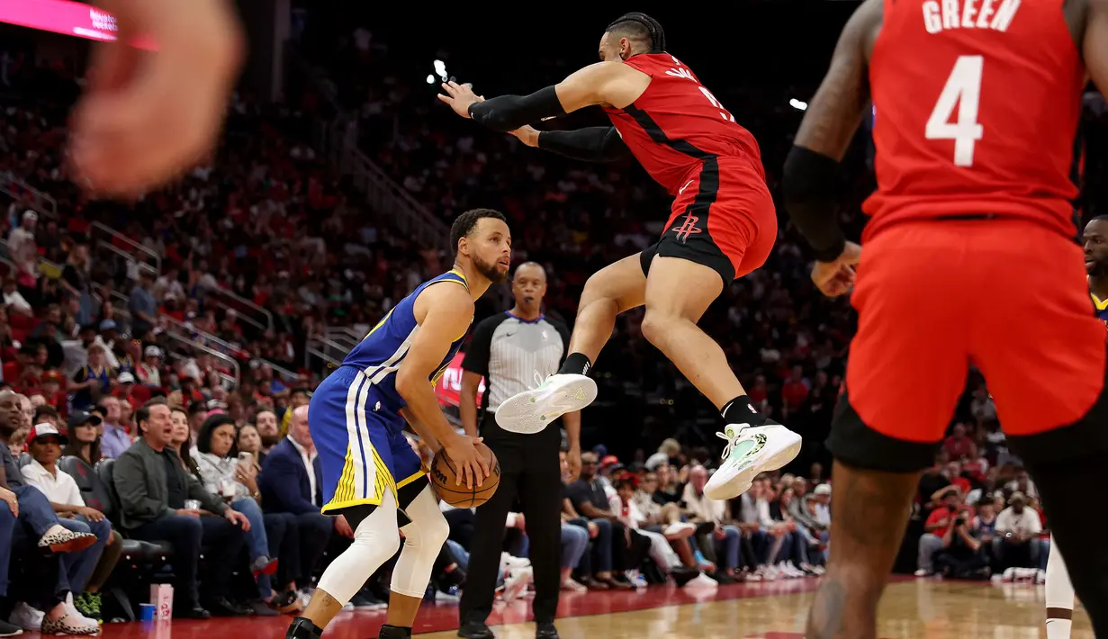Pemain Golden State Warrirors, Stephen Curry (kiri) berusaha mengecoh pemain Houston Rockets, Dillon Brooks pada laga lanjutan NBA 2023/2024 di Toyota Center, Houston, Texas, 29 Oktober 2023 waktu setempat. (AFP/Getty Images/Tim Warner)