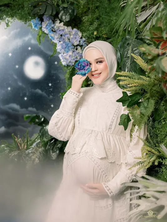 <p>Pada potret yang dibagikan, Cut Meyriska terlihat menawan mengenakan dress dan hijab warna putih. (Instagram/Rogerojey).</p>