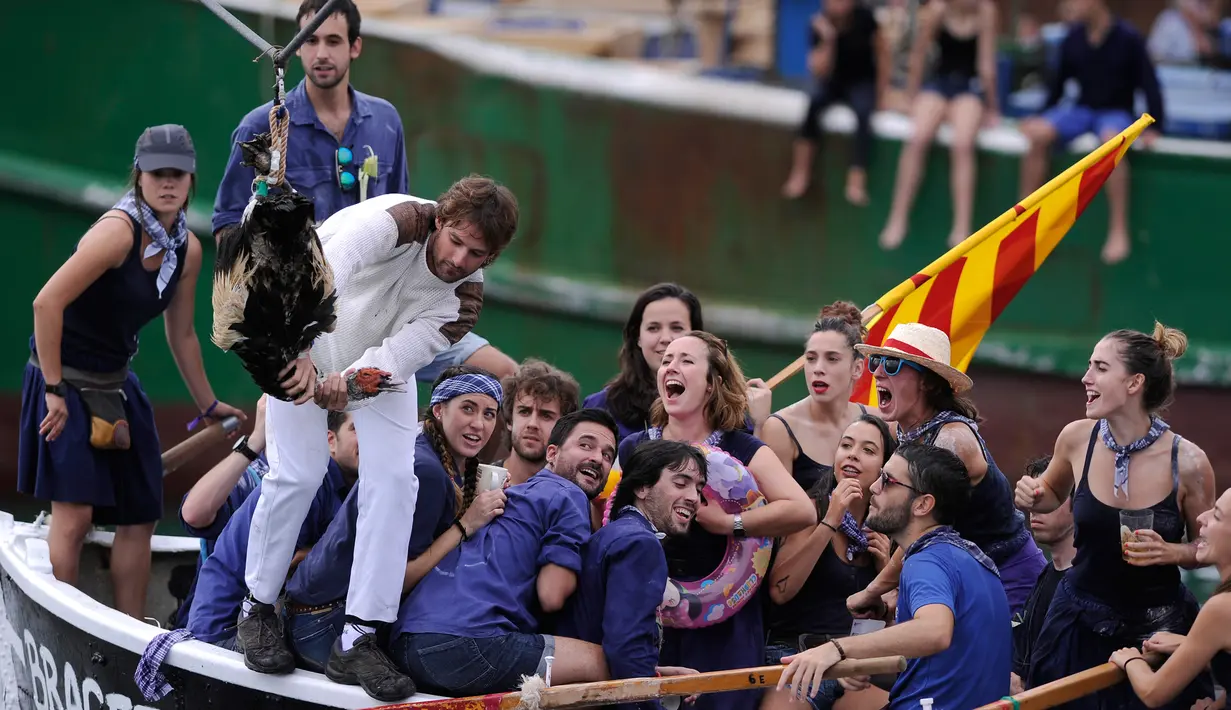 Peserta memegang seekor angsa mati saat perayaan "Antzar Eguna" (Hari Angsa) di pelabuhan desa Basque Lekeitio, Spanyol (5/9). (AFP/Ander Gillenea)