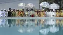 Para imam Kristen Ortodoks Ethiopia berkumpul di sebelah kolam air saat para pengikutnya menabuh genderang dan menyanyikan lagu-lagu religi untuk merayakan hari kedua festival Timkat, atau Epiphany, di ibu kota Addis Ababa, Ethiopia, Rabu (19/1/2022). (AP Photo)