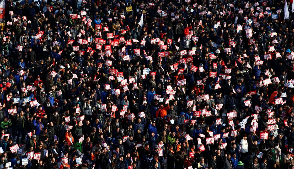 Massa membawa poster bertuliskan "Park Geun-Hye Out!" saat menggelar unjuk rasa di jalan utama Seoul, Korea Selatan, Sabtu (12/11). Park Geun-Hye diminta mundur atas tuduhan korupsi, kolusi, dan nepotisme (KKN). (REUTERS/Jeon Heon-kyun)