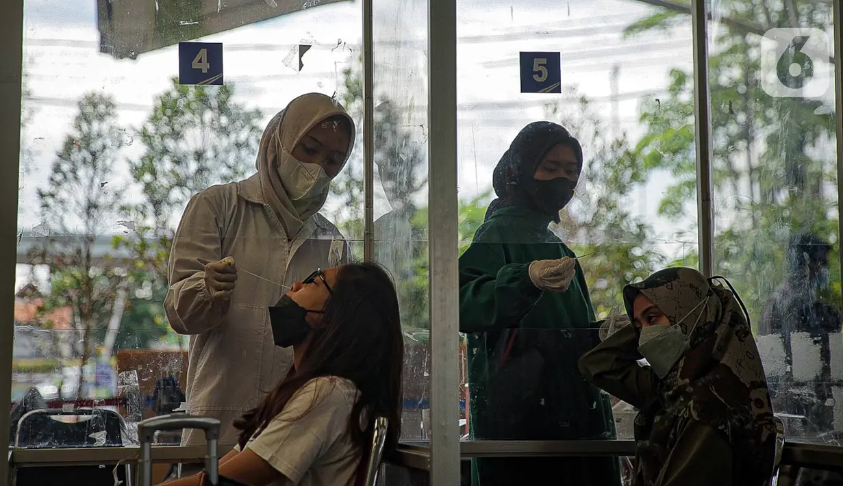 Sejumlah calon penumpang menjalani tes swab PCR di Stasiun Pasar Senen, Jakarta, Jumat (24/12/2021). Mulai hari ini, penumpang kereta wajib menunjukkan hasil negatif tes PCR. (Liputan6.com/Faizal Fanani)