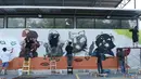 Sejumlah seniman grafiti membuat mural harimau kumbang di Bangkok, Thailand (16/3). Aksi ini sebagai protes perburuan liar ilegal oleh konglomerat konstruksi Premchai Karnasuta. (AFP Photo/Lillian Suwanrumpha)