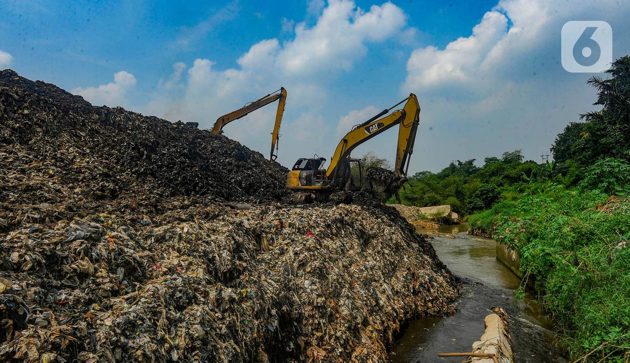 Alat berat mengangkat sampah untuk mengurangi volume longsor tempat pembuangan akhir (TPA) Cipayung yang menimbun Kali Pesanggrahan di Depok, Jawa Barat, Selasa (30/4/2024). (merdeka.com/Arie Basuki)