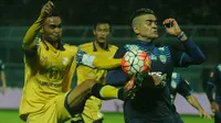 Kapten Barito Putera, Rizky Pora berebut bola dengan striker Arema Cronus, Cristian Gonzales dalam laga yang berlangsun di Stadion Kanjuruhan, Kabupaten Malang, Selasa (26/7/2016). (Bola.com/Iwan Setiawan)