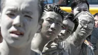 Wajah sejumlah orang yang terkena air lumpur selama Festival Lumpur Boryeong di Pantai Daecheon di Boryeong, Korea Selatan, (14/7). Festival lumpur tahunan ke-21 ini menampilkan gulat lumpur. (AP Photo / Ahn Young-joon)