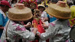 Sejumlah warga menyiapkan patung dewa saat Festival Cheung Chau Bun di Hong Kong (5/3). Festival ini diadakan oleh masyarakat di pulau kecil yang berada sekitar 10 kilometer dari Pulau Hong Kong yang bernama Pulau Cheung Chau. (AP Photo/Vincent Yu)