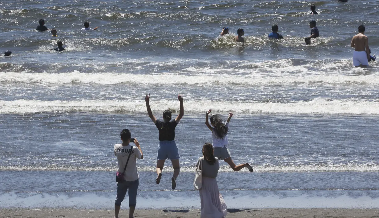 Orang-orang menikmati Pantai Shonan untuk menyejukkan diri dari teriknya musim panas di Fujisawa, dekat Tokyo, Selasa, (11/8/2020). (AP / Koji Sasahara)