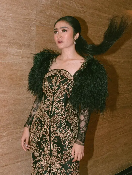 Febby Rastanty dikenal cantik dengan rambutnya yang diikat ke belakang. Rambut panjangnya terlihat indah senada dengan nuansa hitam hiasan di pundaknya. Motif tumbuhan Nusantara makin memperkuat kesan stunning Febby Rastanty. (Liputan6.com/IG/@febbyrastanty).