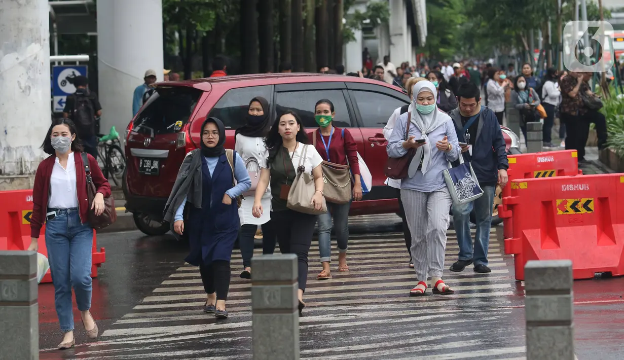 Pekerja berjalan kaki saat jam pulang di kawasan Sudirman, Jakarta, Jumat (7/2/2020). BPJS Ketenagakerjaan yang kini bernama BP Jamsostek menargetkan sekitar 23,5 juta tenaga kerja baru masuk dalam daftar kepesertaan pada 2020. (Liputan6.com/Angga Yuniar)