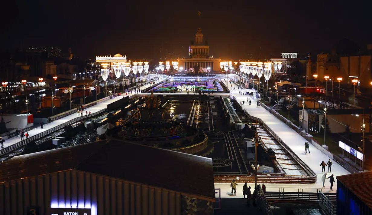 Suasana saat orang berseluncur dalam pembukaan arena seluncur es di VDNKh (Pameran Prestasi Ekonomi Nasional), Moskow, Rusia, Jumat (27/11/2020). Area tersebut terbuat dari lapisan es buatan lebih dari 20.000 meter persegi. (AP Photo/Alexander Zemlianichenko)