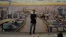 Seniman jalanan Australia James Cochran berpose di depan mural lanskap kota London buatannya di dinding Network Rail oleh Blackfriars Station, di London (5/10/2020). Ini adalah pertama kalinya Cochran melukis pemandangan kota sebagai karya seni jalanan di luar studionya. (AP Photo/Matt Dunham)