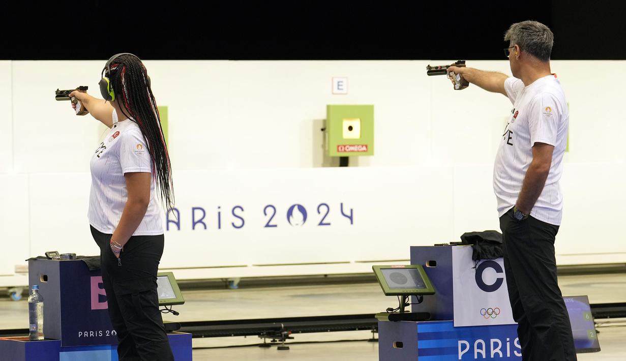 Penembak Turki, Yusuf Dikec (kanan) dan Sevval Ilayda Tarhan saat bertanding dalam perebutan medali emas cabang olahraga menembak nomor 10m Air Pistol beregu campuran Olimpiade Paris 2024 di Chateauroux Shooting Centre, Paris, Prancis, Rabu (30/07/2024). (AP Photo/Manish Swarup)