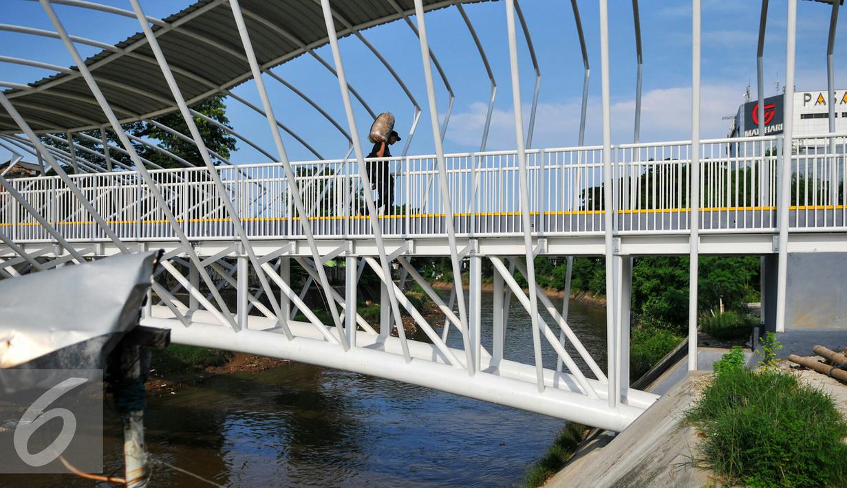 Warga melintas di jembatan penyeberangan orang (JPO) Jayakarta, Manggarai, Jakarta, Rabu (27/4/2016). Warga Manggarai kini dapat melewati sungai Ciliwung melalui JPO Jayakarta. (Liputan6.com/Yoppy Renato)