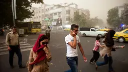 Sempat terjadi kepanikan, beberapa warga Iran terlihat berjalan di tengah-tengah debu pasir di Teheran, Iran, (2/6/2014). (AFP PHOTO/ISNA/Hamidreza Dastjerdi)