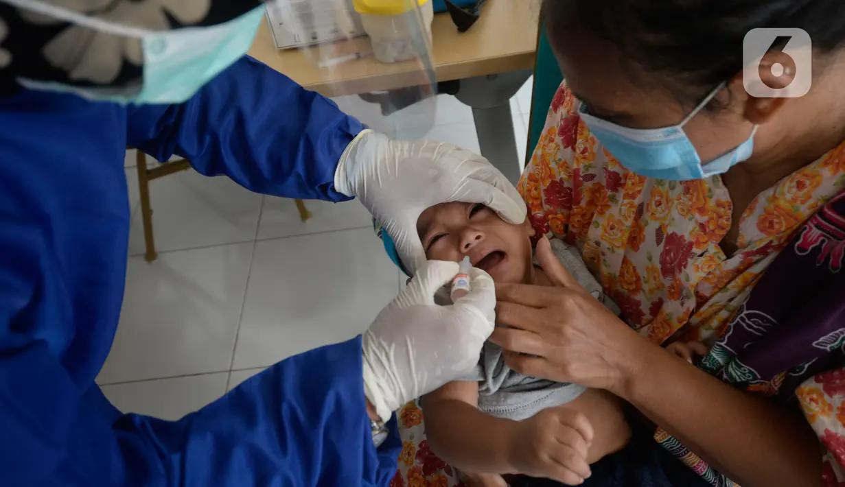 Perawat dibantu kader Posyandu memberikan vaksin campak, vaksin pentabio berisi vaksin DPT, Hepatitis B dan Haemophilus Influenzae dan Imunisasi Polio terhadap anak di RW 09, Kelurahan Pondok Benda, Tangerang Selatan, Senin (14/12/2020). (merdeka.com/Dwi Narwoko)