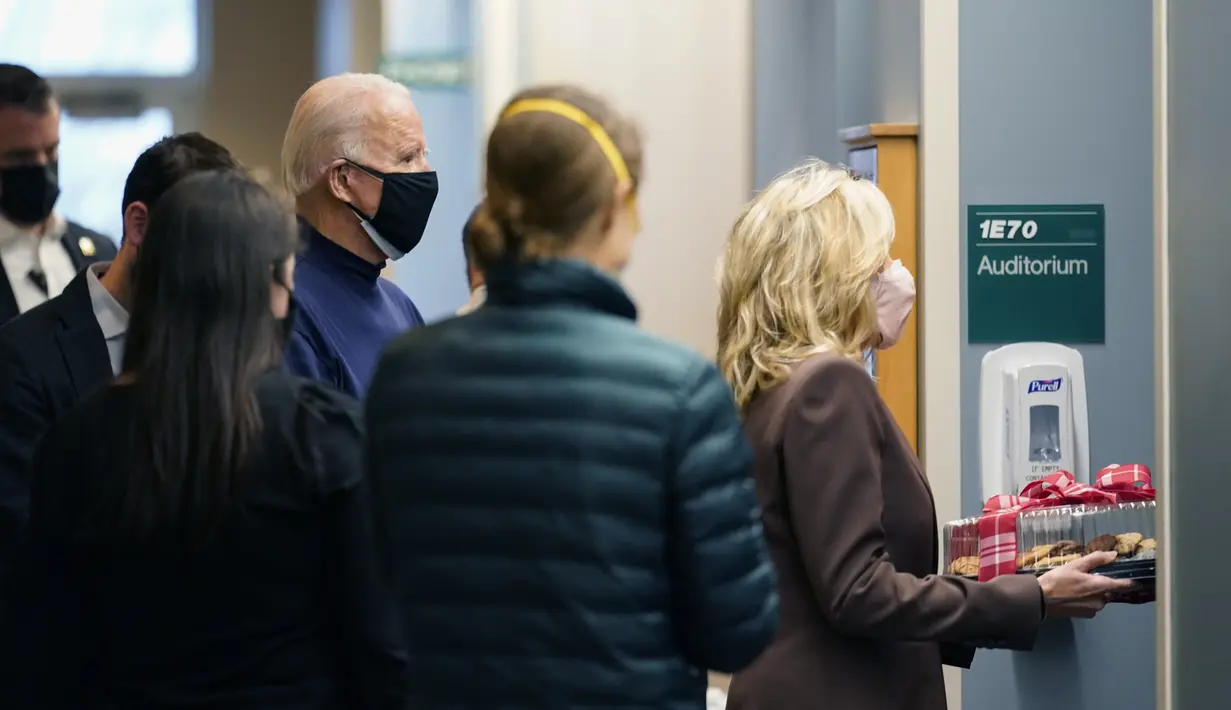 Presiden Amerika Serikat terpilih, Joe Biden dan istrinya Jill Biden membawa nampan kue untuk pekerja garis depan di Rumah Sakit Christiana di Newark, Delaware, Senin (21/12/2020). Joe Biden usai menerima dosis pertama vaksin virus corona Pfizer-BioNTech. (AP Photo/Carolyn Kaster)