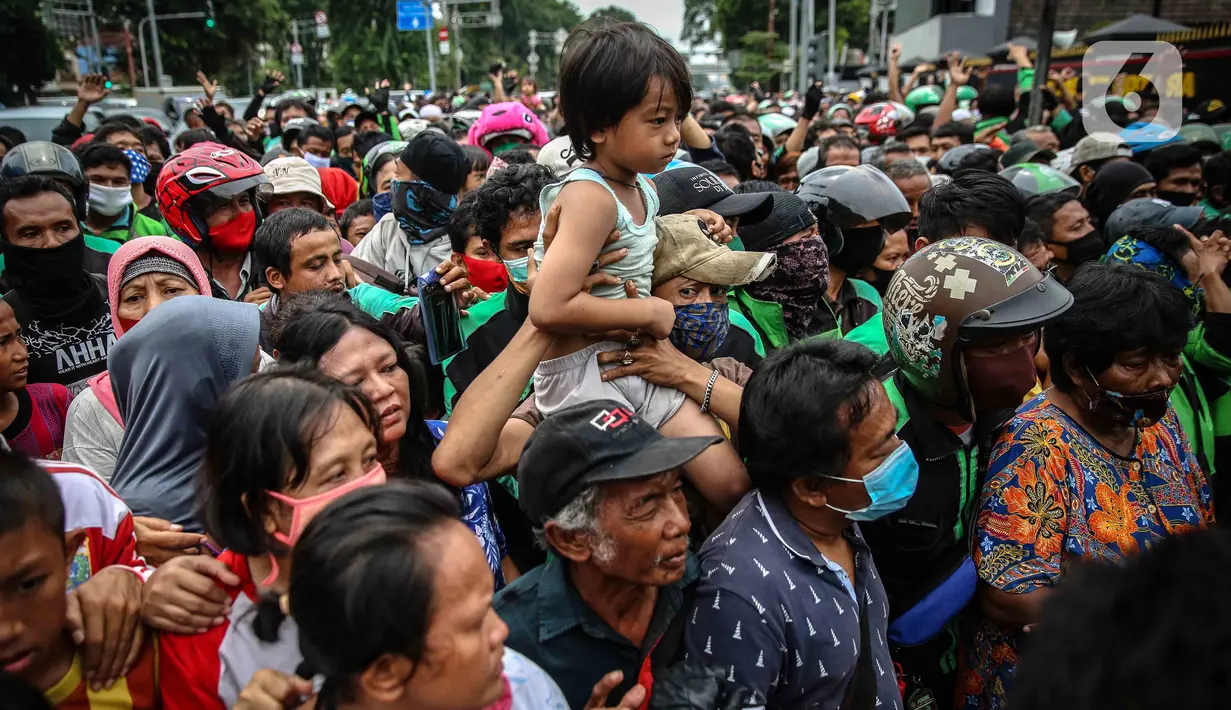 Anak-anak terlihat saat warga dan pengemudi ojek online mengantre nasi kotak serta masker dari TNI di Markas Komando Gabungan Wilayah I, Jakarta, Selasa (21/4/2020). Dalam rangka Hari Kartini, TNI membagikan makanan dan masker kepada masyarakat. (Liputan6.com/Faizal Fanani)