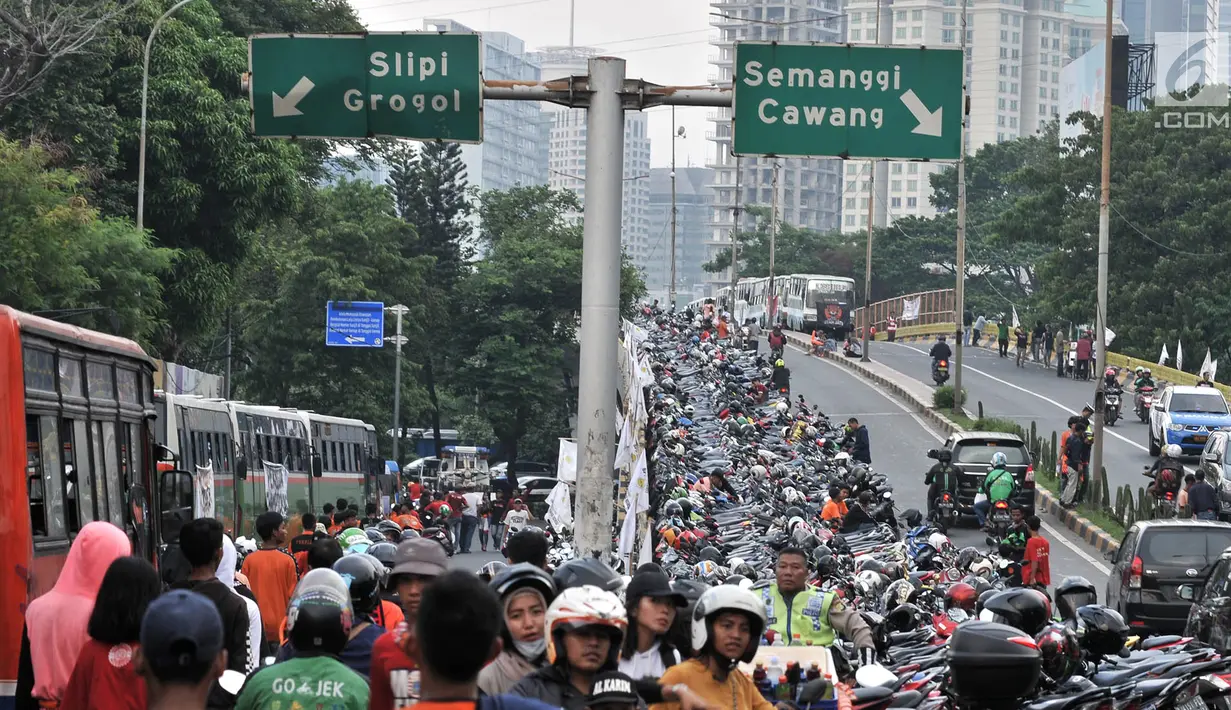 Ratusan sepeda motor terparkir di sepanjang jalan layang atau flyover Gerbang Pemuda, Jakarta, Minggu (9/12). Kendaraan bermotor milik penonoton sepak bola laga Persija vs Mitra Kukar diparkir di trotoar hingga ke flyover. (merdeka.com/Iqbal S. Nugroho)