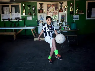 Seorang bocah mengenakan baju Juventus dengan nama Arturo Vidal di pinggiran kota Santiago. (Pablo Sanhueza)