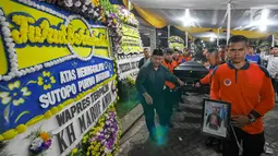 Petugas BNPB membawa jenazah Kapus Data Informasi dan Humas BNPB Sutopo Purwo Nugroho untuk diberangkatkan ke Bandara Soekarno-Hatta usai disemayamkan di rumah duka Raffles Hils, Cimanggis, Depok, Senin (7/7/2019). Sutopo diterbangkan ke Bandara Adi Soemarmo. (Liputan6.com/Herman Zakharia)
