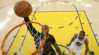 Pemain Cleveland Cavaliers, LeBron James memasukan bola kedalam ring saat pertadingan melawan Golden State Warriors di gim kelima Final NBA 2017 di Oakland, California (12/6). (Ezra Shaw/Pool Photo via AP)