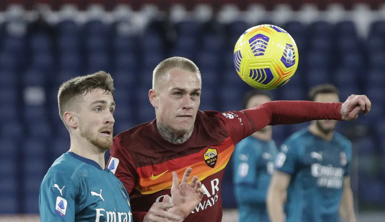 Gelandang AC Milan, Alexis Saelemaekers berebut bola dengan bek AS Roma,  Rick Karsdorp pada pertandingan Liga Serie A Italia di stadion Olimpiade, Italia,Senin (1/3/2021). Hasil ini membuat AC Milan menempel ketat rival mereka Inter Milan yang berada di puncak klasemen. (AP Photo/Gregorio Borgia)