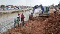 Pekerja menyelesaikan pengerjaan jalan di lokasi normalisasi sungai Ciliwung, Jakarta, Selasa (27/2). Proses normalisasi Sungai Ciliwung kembali dilanjutkan setelah terhenti karena meningginya air. (Liputan6.com/Yoppy Renato)