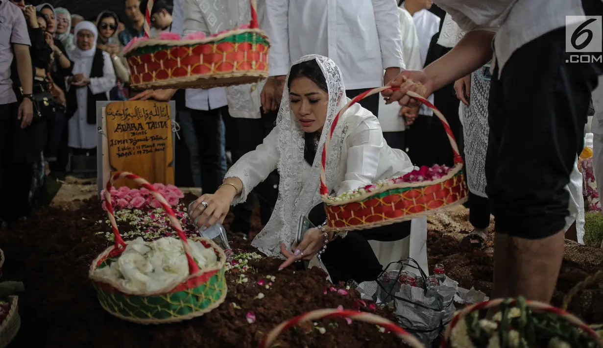 Istri Edhie Baskoro Yudhoyono alias Ibas Yudhoyono, Aliya Rajasa menyiramkan air di atas makam almarhum istri Rasyid Rajasa,  Adara Taista di TPU Tanah Kusir, Jakarta, Senin (21/5). (Liputan6.com/Faizal Fanani)