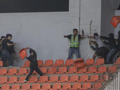 Sejumlah pendukung Persib Bandung (kiri) dan pendukung Persis Solo bersitengan saat pertandingan pekan ke-32 BRI Liga 1 2022/2023 antara Persib Bandung melawan Persis Solo yang berlangsung di Stadion Pakansari, Bogor, Selasa (04/04/2023). (Bola.com/Bagaskara Lazuardi)