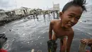 Keceriaan seorang anak saat bermain air di pantai penuh sampah yang terbawa arus di Muara Angke, Jakarta, Rabu (10/2). Genangan sampah yang terbawa arus oleh angin musim barat ini tak menyurutkan anak-anak untuk bermain air. (Liputan6.com/Faizal Fanani)