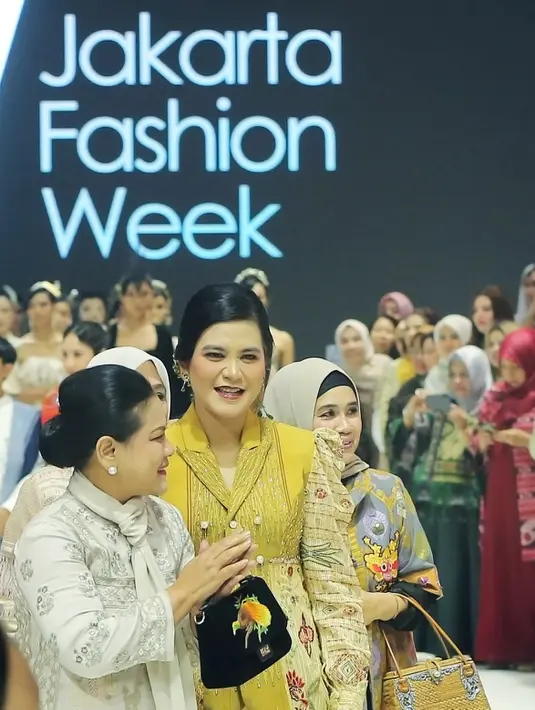 Tatanan rambut sanggul klasik, ditambah dengan aksesori anting mutiara menambah elegansi pada penampilan Ibu Negara tersebut. Untuk alas kaki, Iriana memilih wedges dengan strap hitam. [Fimela/Bambang E. Ros]