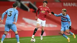 Striker MU, Edinson Cavani (tengah) membawa bola dari kawalan bek West Ham United Aaron Cresswell (kiri) dan gelandang Said Benrahma pada pertandingan perdelapan final Piala FA di Old Trafford, Inggris (10/2/2021).  Kemenangan ini membuat MU lolos ke perempat final Piala FA. (Michael Regan/POOL/AFP)