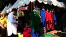 Pengunjung melihat stan pedagang aksesoris pakaian khas Betawi merapikan barang dagangannya dalam Lebaran Tenabang 2022 di kawasan Tanah Abang, Jakarta, Sabtu (4/6/2022). Kegiatan yang menampilkan berbagai kesenian Betawi, makanan tradisional, perlombaan, dan bazar UMKM itu mengangkat tema KolaborAksi. (Liputan6.com/Angga Yuniar)