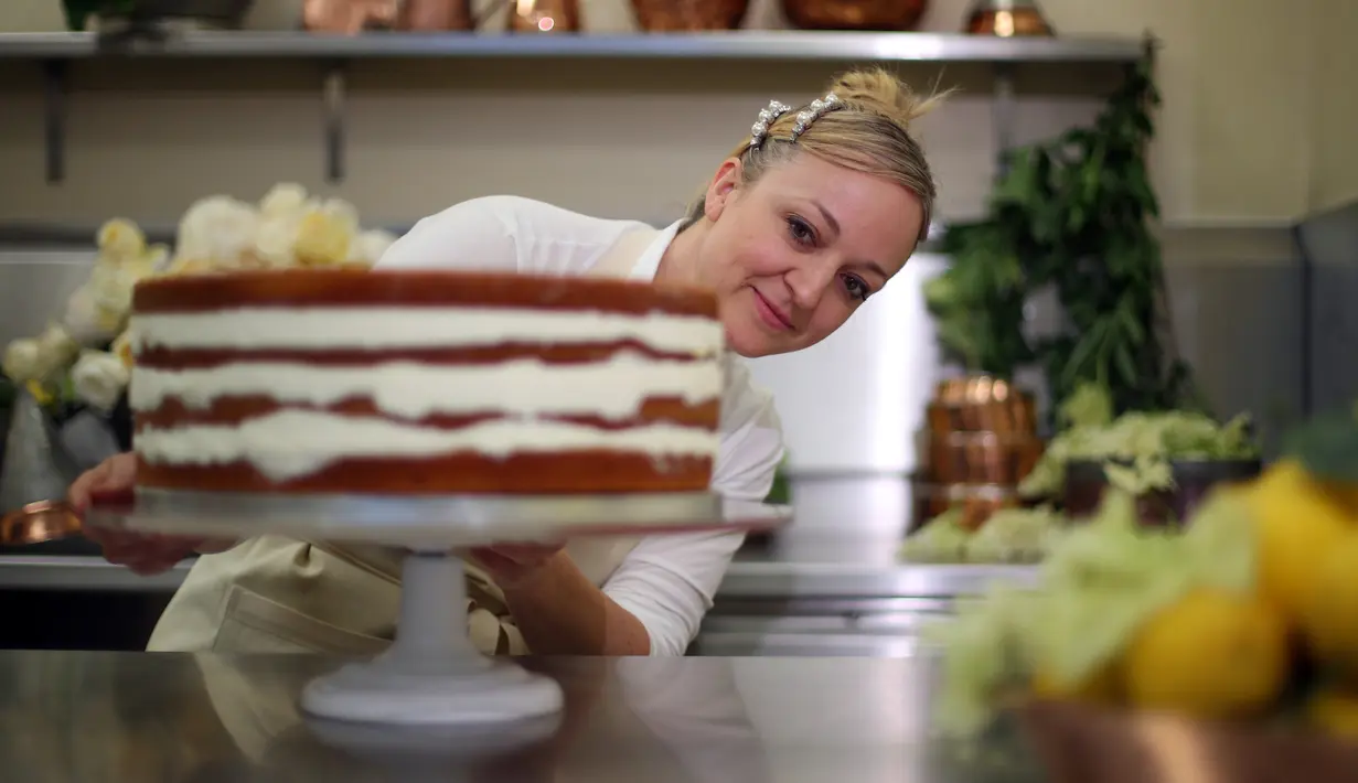 Pemilik Violet Bakery, Claire Ptak menyelesaikan pembuatan kue pengantin Pangeran Harry dan Meghan Markle di dapur Istana Buckingham, London, Kamis (17/5). Harry dan Meghan akan menikah pada 19 Mei mendatang di Windsor Castle. (HANNAH MCKAY/POOL/AFP)