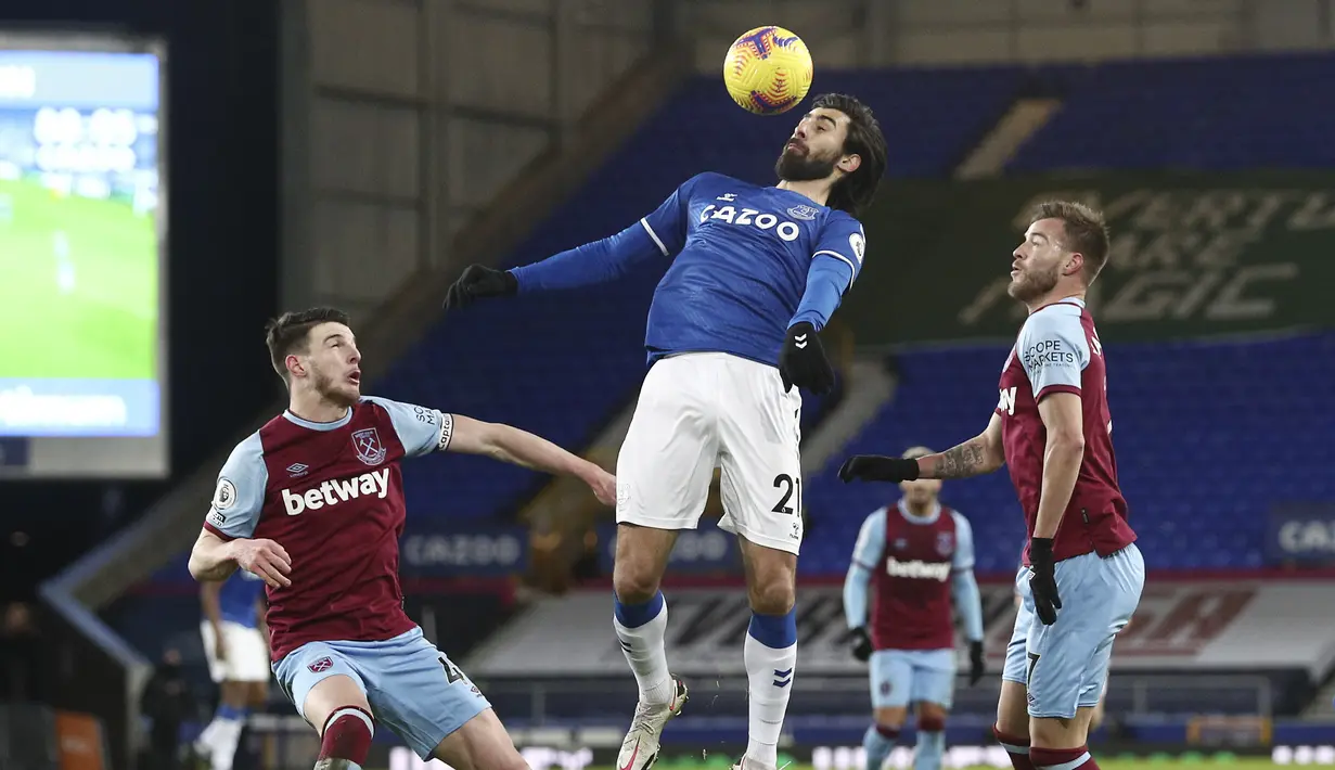 Gelandang Everton, Andre Gomes (tengah) mengontrol bola dari kawalan dua pemain West Ham Declan Rice dan Andriy Yarmolenko pada pertandingan Liga Inggris di Goodison Park, Sabtu (2/1/2021). Everton terancam terlempar dari empat besar tergantung hasil laga-laga lain. (Jan Kruger, Pool via AP)