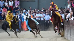Para joki bersaing dalam balapan kuda Italia historis Palio di Siena, Italia (16/8). Perlombaan ini sudah digelar sejak abad pertengahan (sekitar tahun 1600-an) dan sampai sekarang tradisinya masih terus dipertahankan. (AFP Photo/Filippo Monteforte)