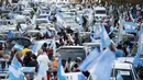 Pengunjuk rasa antipemerintah memegang bendera Argentina selama berunjuk rasa menentang berbagai masalah termasuk kebijakan ekonomi pemerintah dan negara untuk melawan penyebaran COVID-19 di Buenos Aires, Argentina, Senin (12/10/2020). (AP Photo/Natacha Pisarenko)