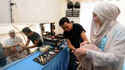 Aktris, Zaskia Adya Mecca (kanan) merapikan kerudung yang dikenakan Wiwi Handayani saat dirias jelang tampil di panggung inBox SCTV di Cibinong Square, Bogor, Jumat (30/1/2015). (Liputan6.com/Helmi Fithriansyah)