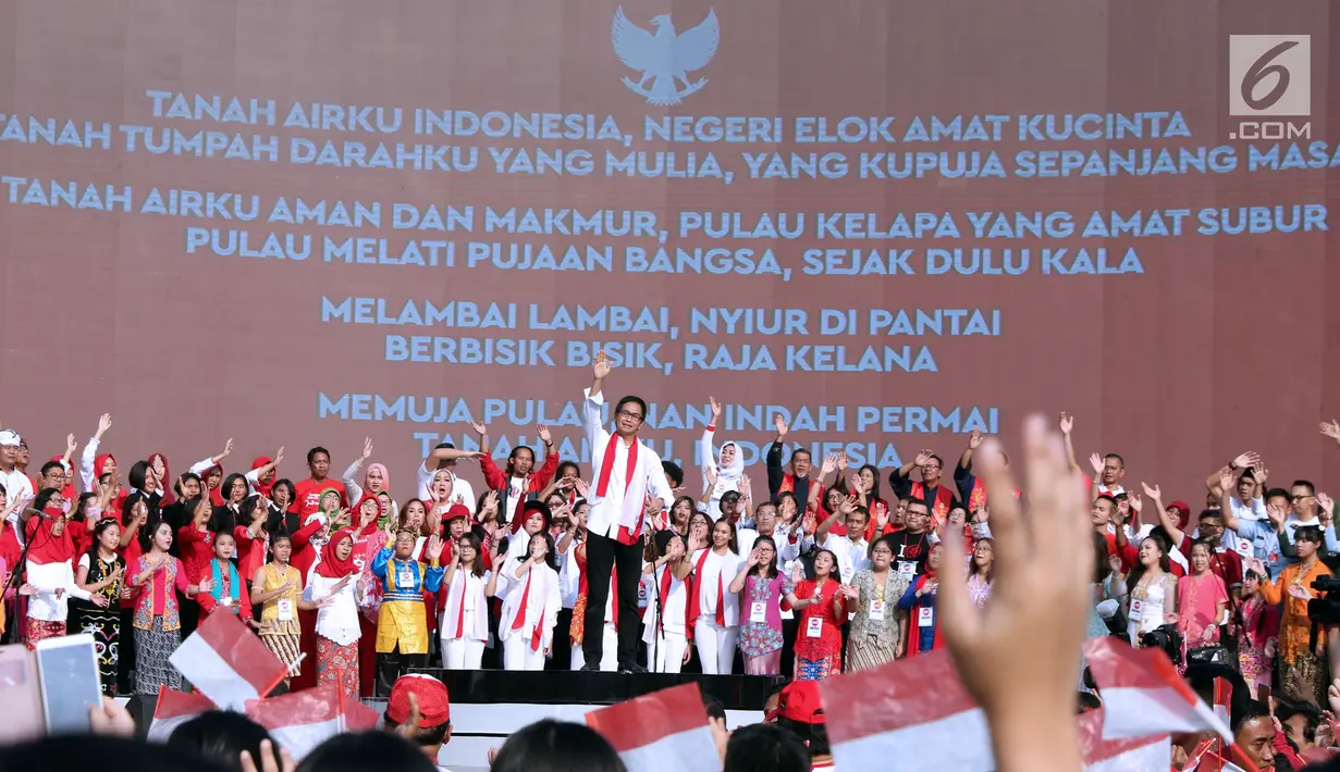 Konduktor, Addie MS memimpin peserta menyanyikan lagu Nyiur Melambai saat gelaran Harmoni Indonesia 2018 di Kompleks Gelora Bung Karno, Jakarta, Minggu (5/8). Lima buah lagu termasuk Indonesia Raya dinyanyikan bersama. (Liputan6.com/Helmi Fithriansyah)