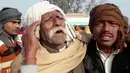 Kesedihan seorang pria di lokasi kecelakaan antara bus sekolah dan truk di Etah, negara bagian Uttar Pradesh, India, Kamis (19/1). Dalam tragedi tersebut selain menewaskan sedikitnya 15 anak, pengemudi bus juga tewas. (KK Production via AP)