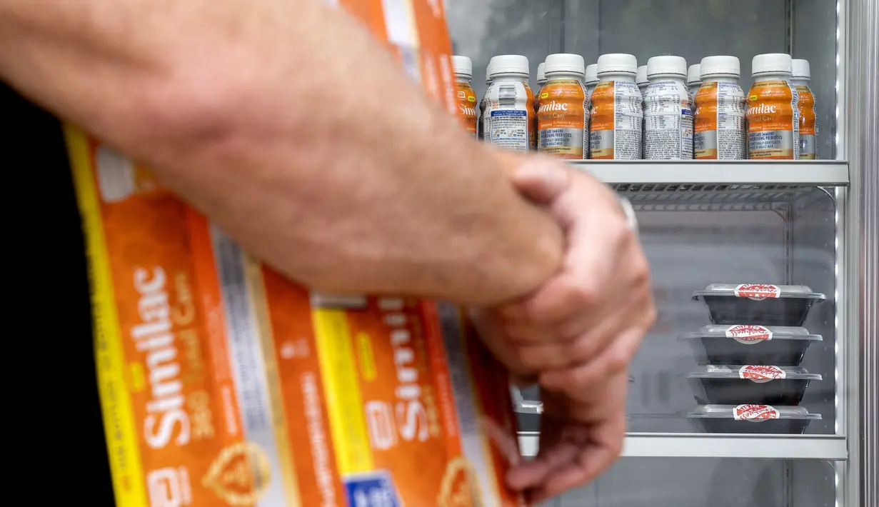 <p>Susu formula bayi terlihat di rak saat pemilik restoran DC Mark Bucher memegang sekotak susu formula Similac di luar Glassmanor Community Center di Oxon Hill, Maryland, Rabu (25/5/2022). Dengan kelangkaan susu formula bayi di Amerika Serikat, Mark Bucher mulai membeli susu formula dari tempat-tempat di mana ada lebih banyak jumlahnya dengan lebih sedikit kebutuhan, dan memberikannya melalui program Feed the Fridge. (Stefani Reynolds/AFP)</p>