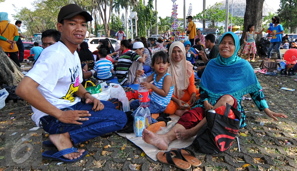 Berwisata bersama keluarga memang menjadi pilihan menarik berkunjung ke TMII, Jakarta, Minggu (19/07/2015). Makan bersama sambil menggelar tiker di tempat wisata menjadi pilihan warga yang mengunjungi tempat wisata TMII. (Liputan6.com/Yoppy Renato)