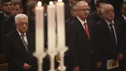Presiden Palestina Mahmoud Abbas (kiri) menghadiri misa Natal di Gereja Nativity, Bethlehem, Jumat ( 25/12/2015). Abbas selalu mengikuti misa yang dirayakan di tempat yang diyakini banyak orang sebagai tempat lahirnya Yesus. (REUTERS /Fadi Arouri )