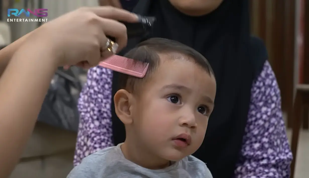 Nagita Slavina tampak begitu semangat untuk memotong rambut putra keduanya, Rayyanza Malik Ahmad alias Cipung. Sebelumnya, istri Raffi Ahmad itu hanya memotong bagian depan membentuk poni. [Youtube/Rans Entertainment]