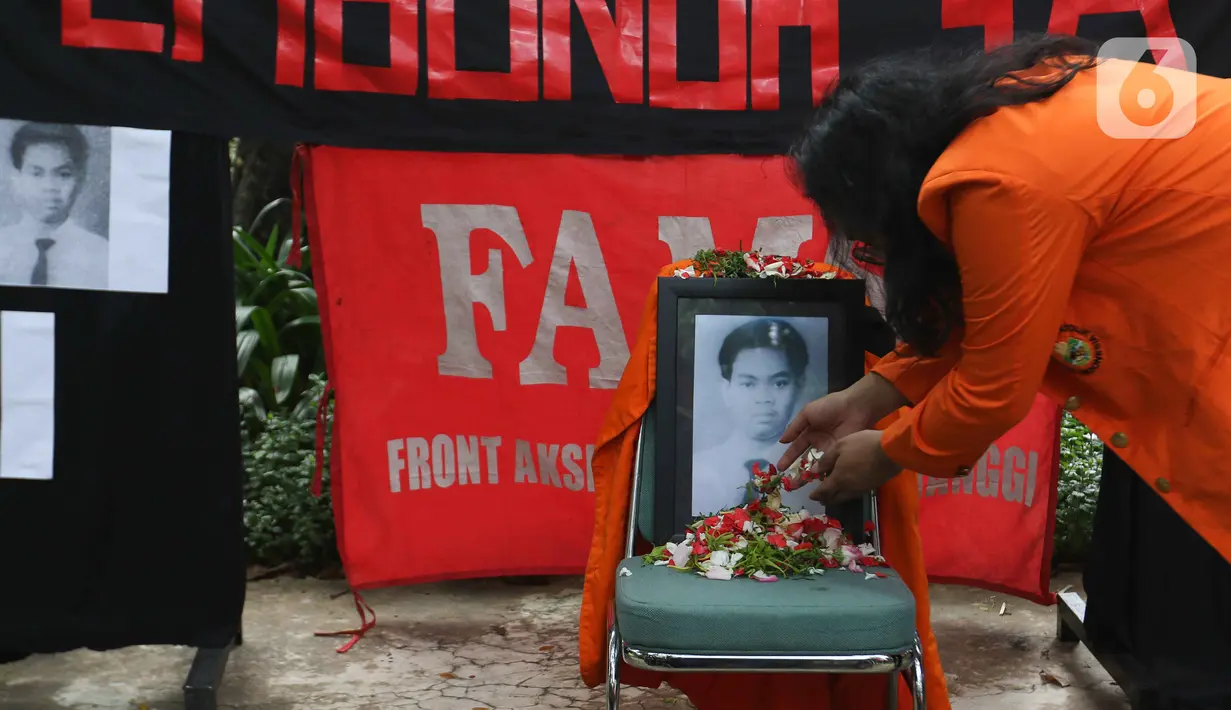 Mahasiswa menaburkan bunga di dekat foto korban Semanggi I di Universitas Atma Jaya, Jakarta, Senin (14/11/2022). Aksi tersebut dalam rangka memperingati 24 tahun Tragedi Semanggi I sekaligus  menuntut pemerintah untuk menuntaskan pelanggaran-pelanggaran HAM berat di Tanah Air, salah satunya Tragedi Semanggi I. (Liputan6.com/Herman Zakharia)