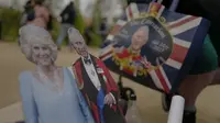 Fans membawa potongan foto Raja Charles III dan Ratu Camilla. (AP Photo/Alberto Pezzali)